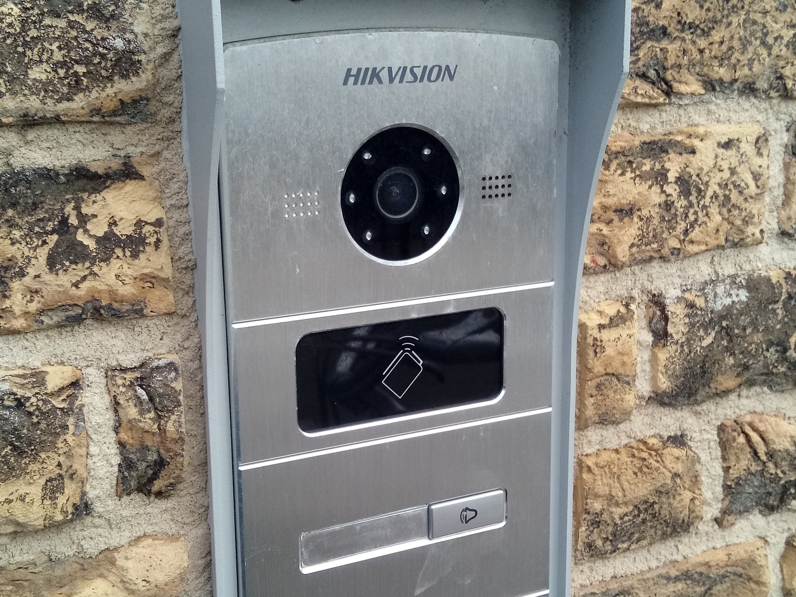 Platine d’interphonie vidéo Hikvision avec caméra, lecteur de badge et bouton d’appel, façade en pierre